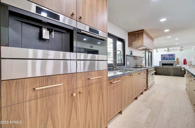 1712 E Fairfield St, Mesa, AZ 85203 - kitchen with modern cabinets, stainless steel stove, light wood-type flooring, recessed lighting, and a fireplace