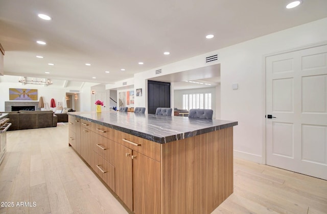 1712 E Fairfield St, Mesa, AZ 85203 - kitchen featuring modern cabinets, light wood-style floors, a large island, a fireplace, and recessed lighting