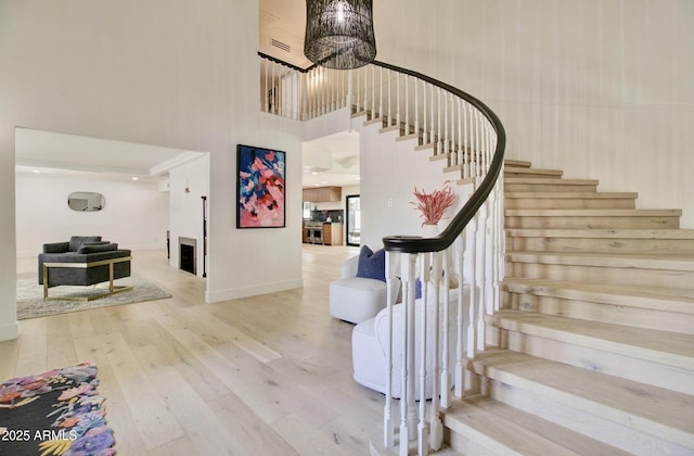 1712 E Fairfield St, Mesa, AZ 85203 - stairs featuring hardwood / wood-style floors, a chandelier, a towering ceiling, and a fireplace