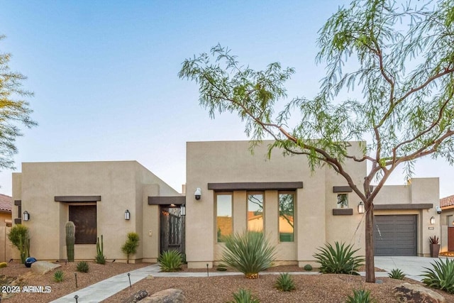 pueblo revival-style home featuring a garage