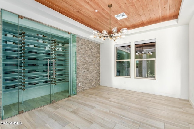 wine room with a notable chandelier, wood ceiling, a tray ceiling, and hardwood / wood-style flooring