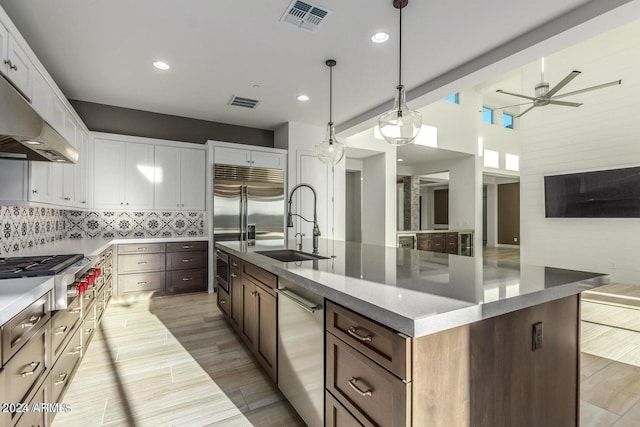 kitchen with ceiling fan, white cabinets, pendant lighting, a large island with sink, and appliances with stainless steel finishes