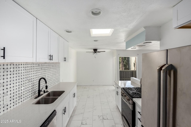 kitchen with tasteful backsplash, appliances with stainless steel finishes, marble finish floor, light countertops, and a sink