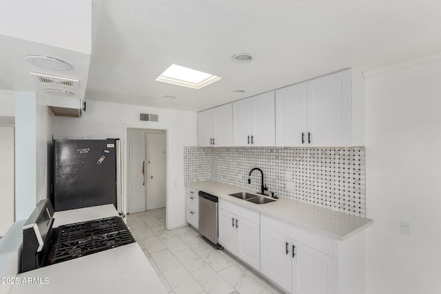 kitchen with a sink, visible vents, marble finish floor, freestanding refrigerator, and dishwasher