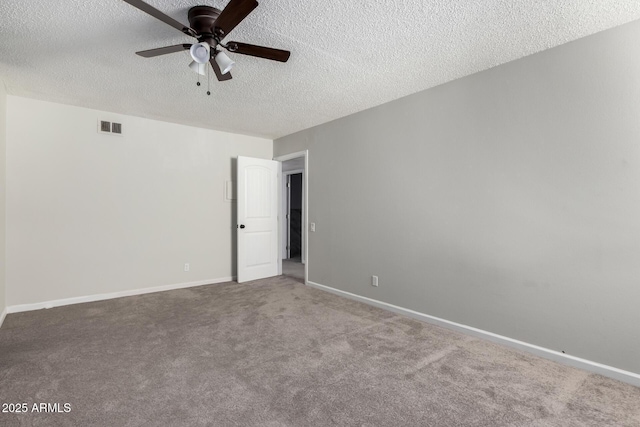 spare room with a textured ceiling, a ceiling fan, visible vents, baseboards, and carpet