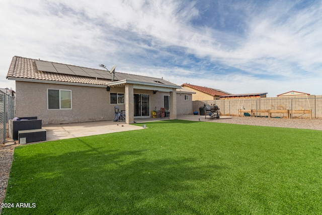 back of house featuring solar panels, a yard, and a patio area