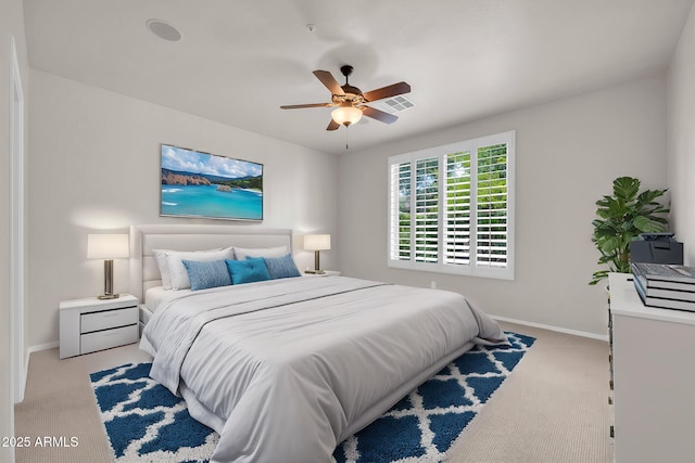 carpeted bedroom featuring baseboards, ceiling fan, and visible vents