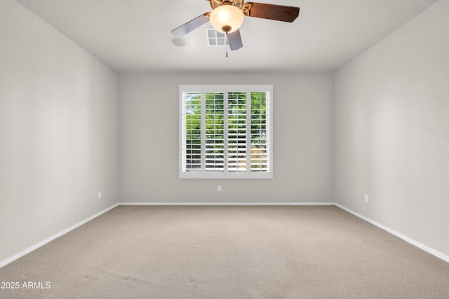 carpeted empty room featuring baseboards, visible vents, and a ceiling fan