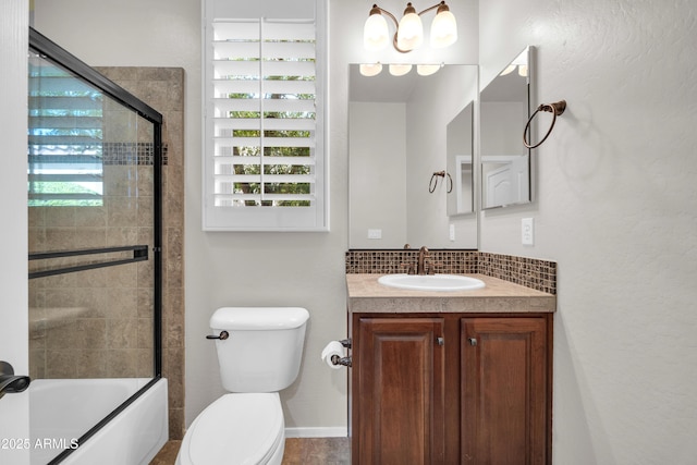 full bath with baseboards, bath / shower combo with glass door, toilet, and vanity