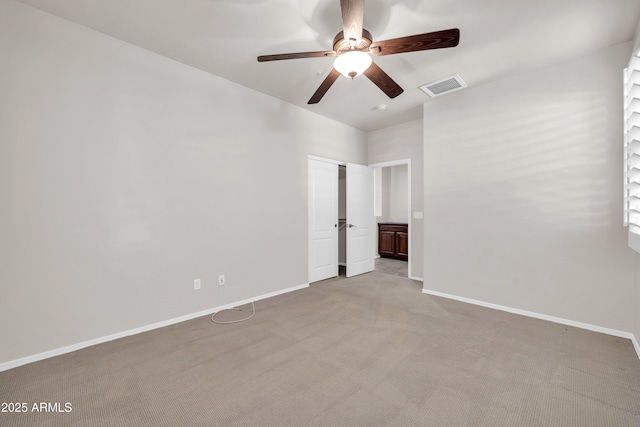 carpeted spare room with a ceiling fan, baseboards, and visible vents