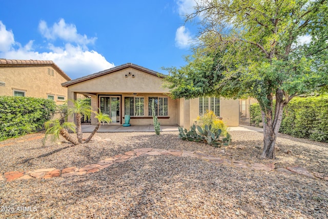 back of house with stucco siding, ceiling fan, and a patio