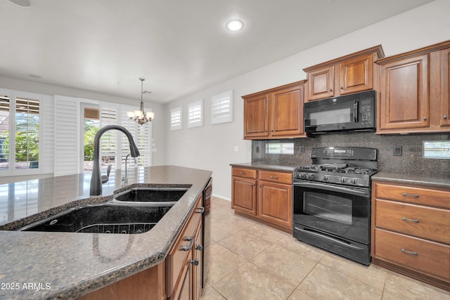 kitchen featuring a sink, tasteful backsplash, brown cabinets, black appliances, and an inviting chandelier