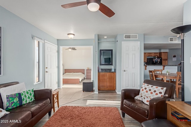 living room with light tile patterned flooring and ceiling fan