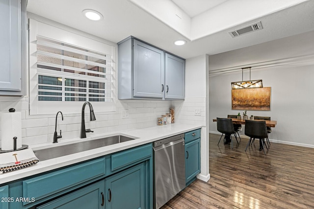 kitchen featuring blue cabinets, dark wood-type flooring, sink, pendant lighting, and dishwasher