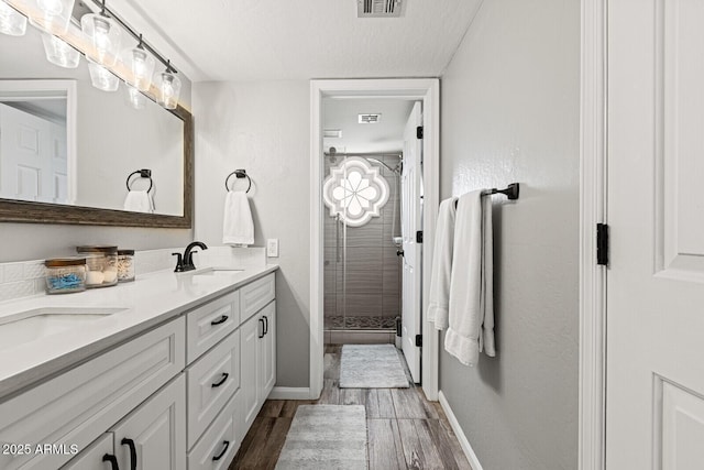 bathroom with vanity, a textured ceiling, and walk in shower