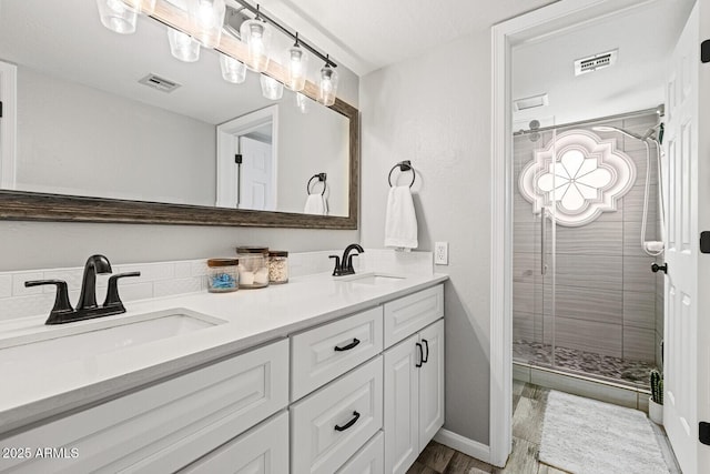 bathroom featuring vanity and a shower with door