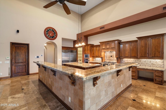 3523 E Presidio Cir, Mesa, AZ 85213 - kitchen with built in appliances, a spacious island, a high ceiling, arched walkways, and a breakfast bar