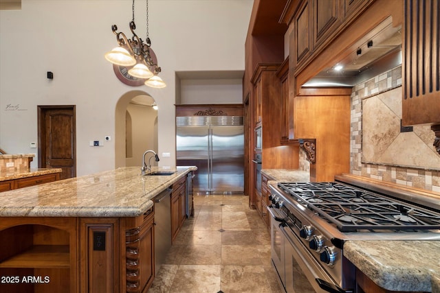3523 E Presidio Cir, Mesa, AZ 85213 - kitchen featuring a sink, stainless steel appliances, brown cabinets, open shelves, and arched walkways
