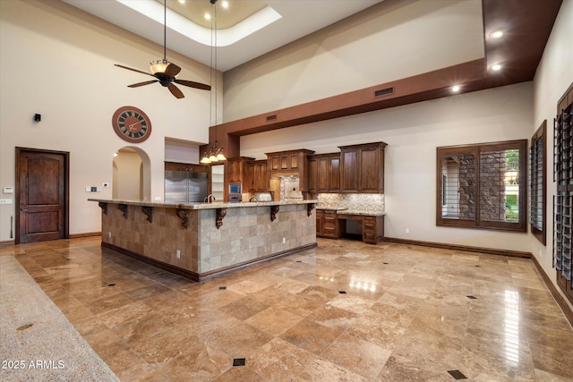 3523 E Presidio Cir, Mesa, AZ 85213 - kitchen featuring built in refrigerator, a high ceiling, baseboards, a breakfast bar, and arched walkways