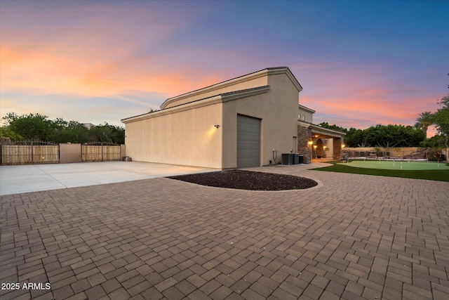 3523 E Presidio Cir, Mesa, AZ 85213 - garage at dusk with decorative driveway, a gate, and central AC