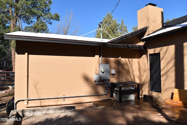 view of side of home featuring brick siding and a chimney