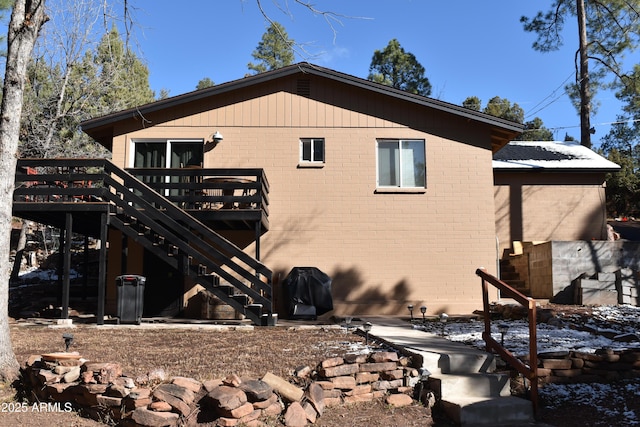 view of home's exterior with brick siding, stairway, and a wooden deck