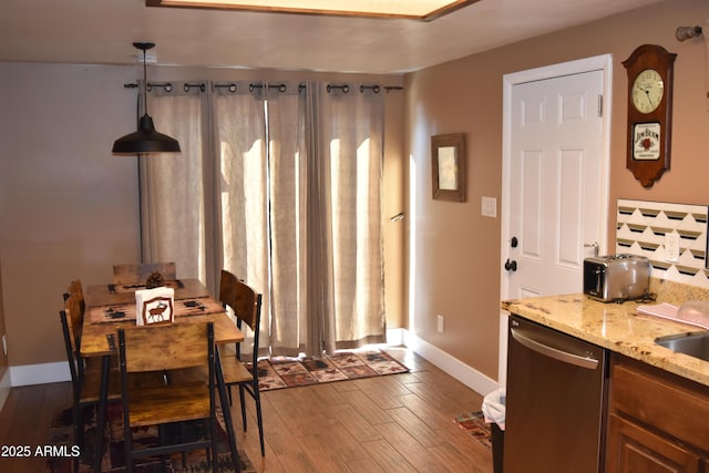 dining room featuring dark wood finished floors and baseboards