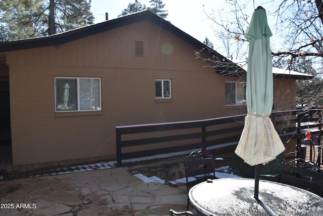 back of property with brick siding and a patio area