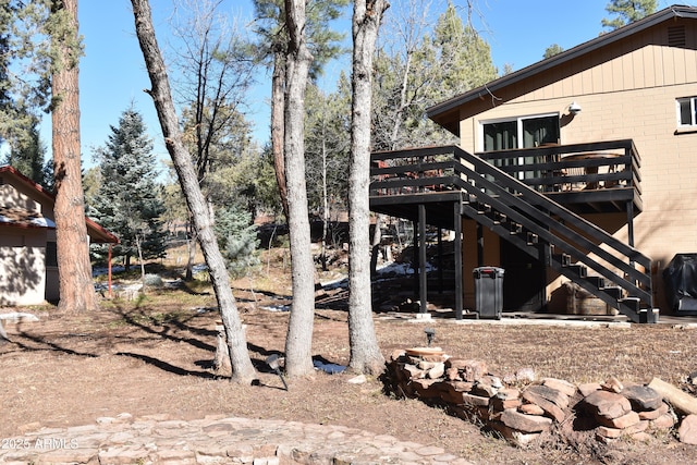 view of home's exterior featuring brick siding, a deck, and stairs