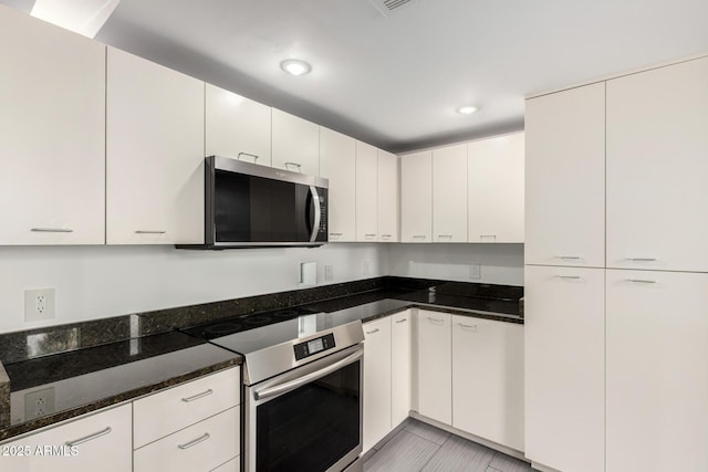 1111 W University Dr Unit 3016, Tempe, AZ 85281 - kitchen with appliances with stainless steel finishes, dark stone countertops, white cabinets, and recessed lighting