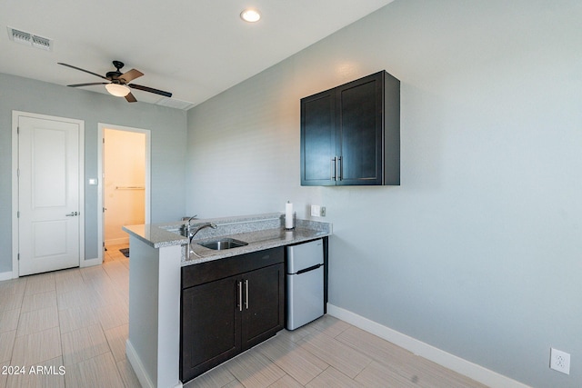 12035 W Roy Rogers Rd, Peoria, AZ 85383 - kitchen with ceiling fan, fridge, sink, and light stone counters