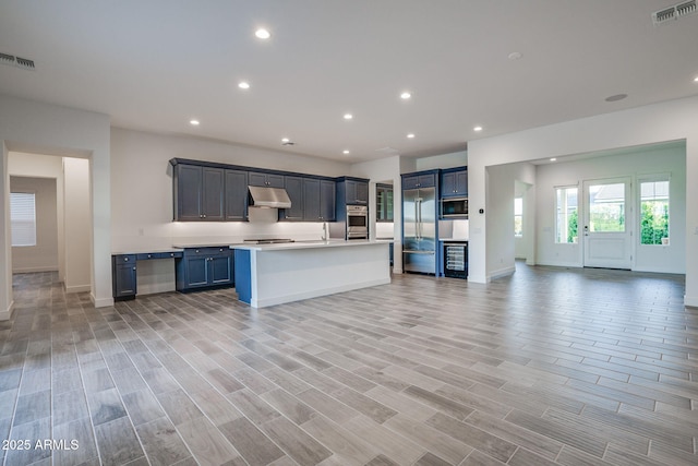 11534 N Jerome St, Surprise, AZ 85388 - kitchen featuring built in appliances, open floor plan, light countertops, under cabinet range hood, and baseboards
