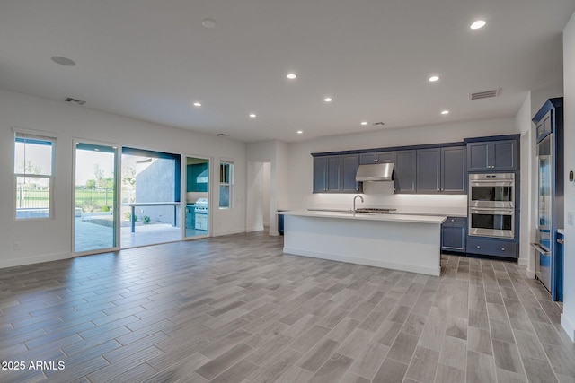 11534 N Jerome St, Surprise, AZ 85388 - kitchen featuring double oven, under cabinet range hood, light countertops, baseboards, and open floor plan