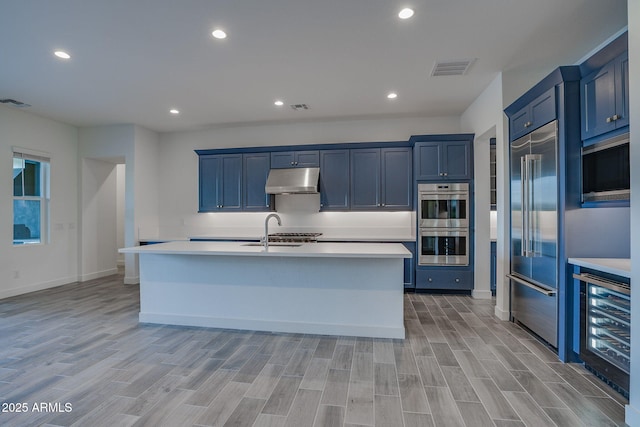 11534 N Jerome St, Surprise, AZ 85388 - kitchen featuring wine cooler, stainless steel appliances, under cabinet range hood, light countertops, and recessed lighting