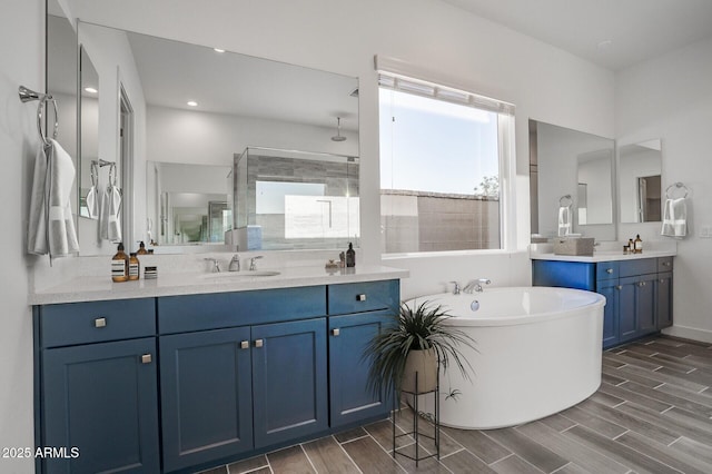 11534 N Jerome St, Surprise, AZ 85388 - bathroom featuring a soaking tub, a tile shower, two vanities, and wood finish floors