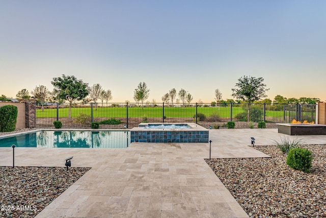 11534 N Jerome St, Surprise, AZ 85388 - pool at dusk featuring an in-ground hot tub and a patio