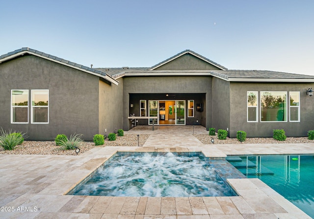 11534 N Jerome St, Surprise, AZ 85388 - rear view of property featuring a patio, stucco siding, and a pool with connected hot tub