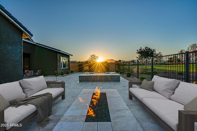 11534 N Jerome St, Surprise, AZ 85388 - patio terrace at dusk with an outdoor living space with a fire pit, a patio, and a fenced backyard