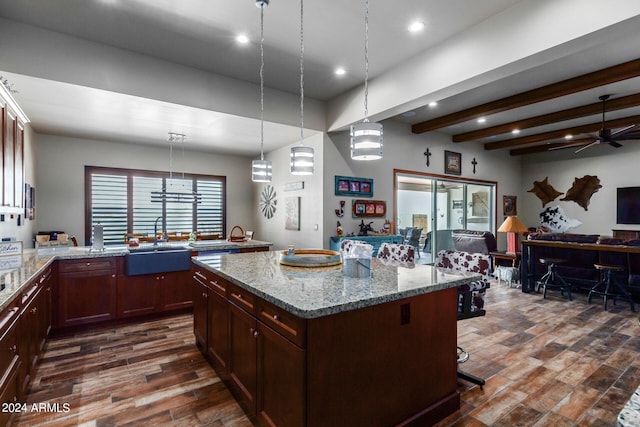 kitchen featuring sink, light stone countertops, hanging light fixtures, and dark hardwood / wood-style floors