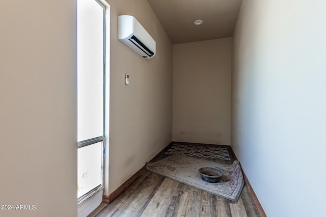 corridor with hardwood / wood-style flooring and a wall mounted AC