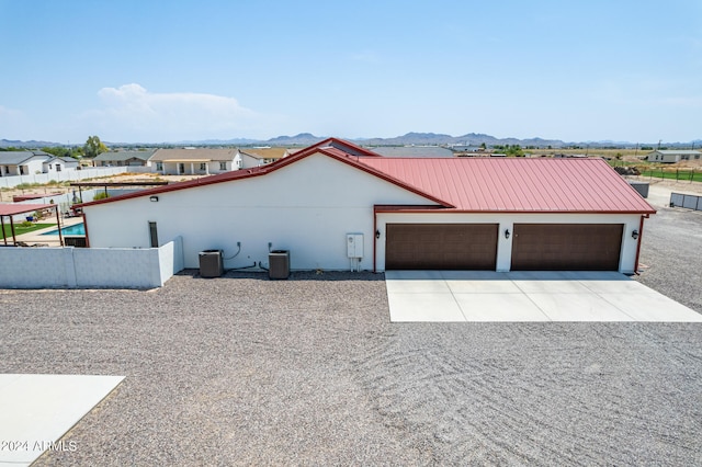 exterior space featuring a mountain view, a garage, and central AC unit