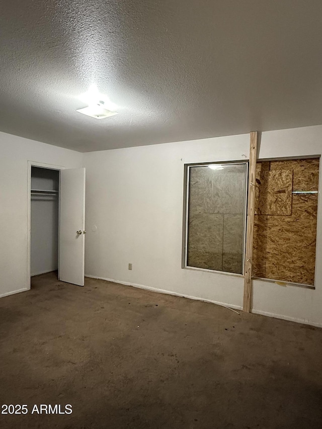 unfurnished bedroom with a textured ceiling, carpet, and a closet