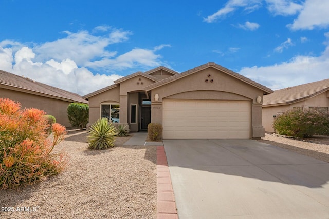 mediterranean / spanish house with concrete driveway, an attached garage, a tiled roof, and stucco siding