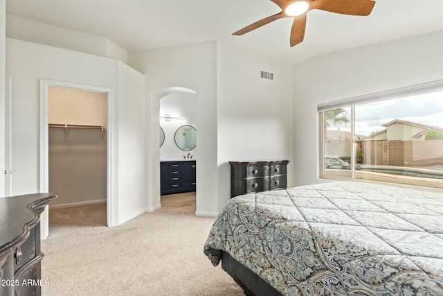 bedroom featuring baseboards, a spacious closet, visible vents, and light colored carpet