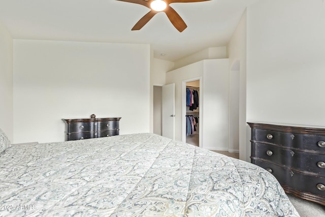 carpeted bedroom featuring a spacious closet and a ceiling fan