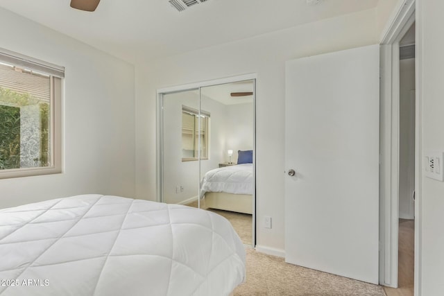 bedroom featuring visible vents, baseboards, ceiling fan, carpet floors, and a closet