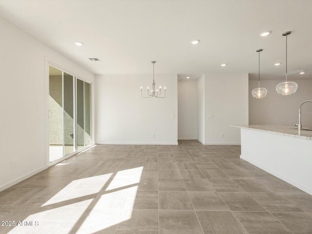 interior space featuring baseboards, a sink, visible vents, and recessed lighting