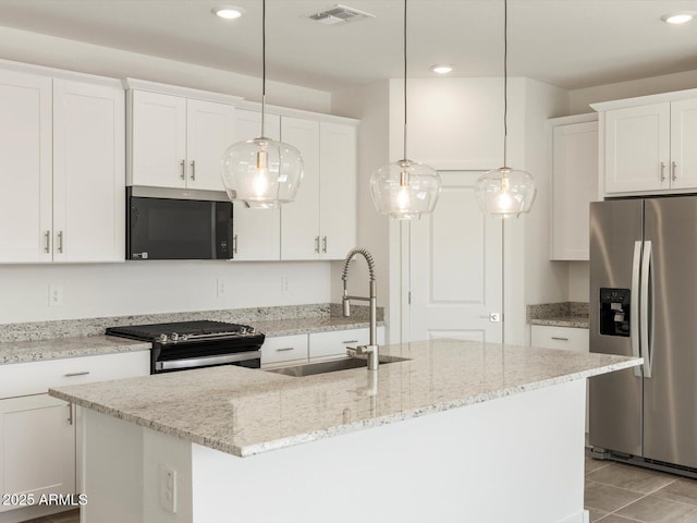 kitchen featuring an island with sink, visible vents, white cabinetry, and stainless steel appliances