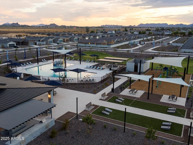 aerial view at dusk featuring a residential view and a mountain view