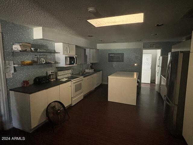 kitchen featuring sink, white electric range, dark hardwood / wood-style floors, and white cabinets